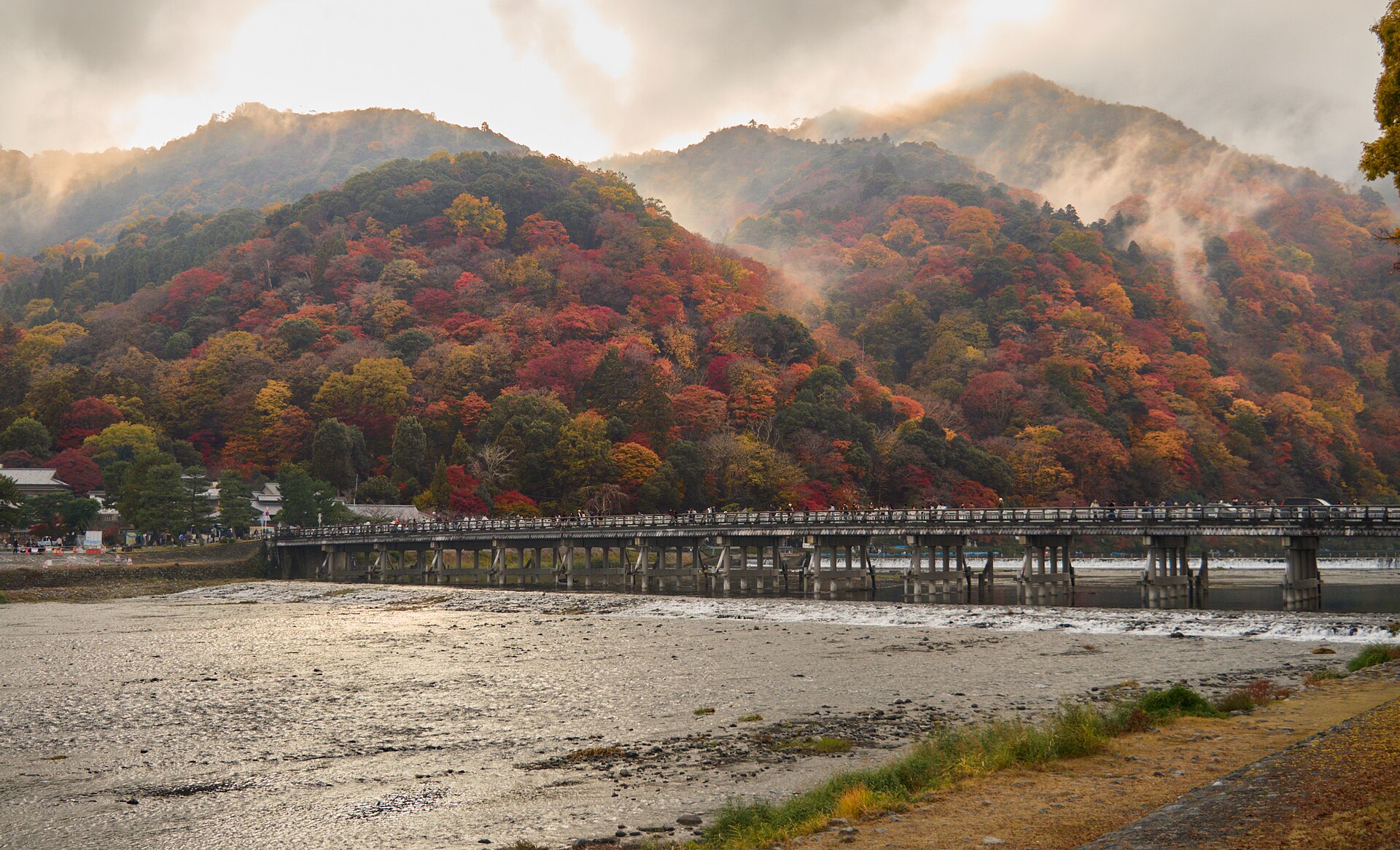 ภูเขาและสะพานโทเก็ตสึเคียวริมแม่น้ำที่อาราชิยามะในฤดูใบไม้เปลี่ยนสี