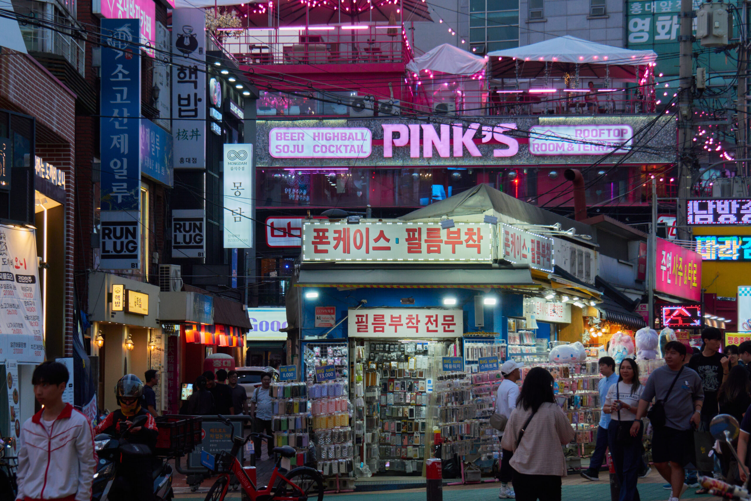 ถนนร้านค้าและผู้คนในย่านฮงแด กรุงโซลช่วงเย็น