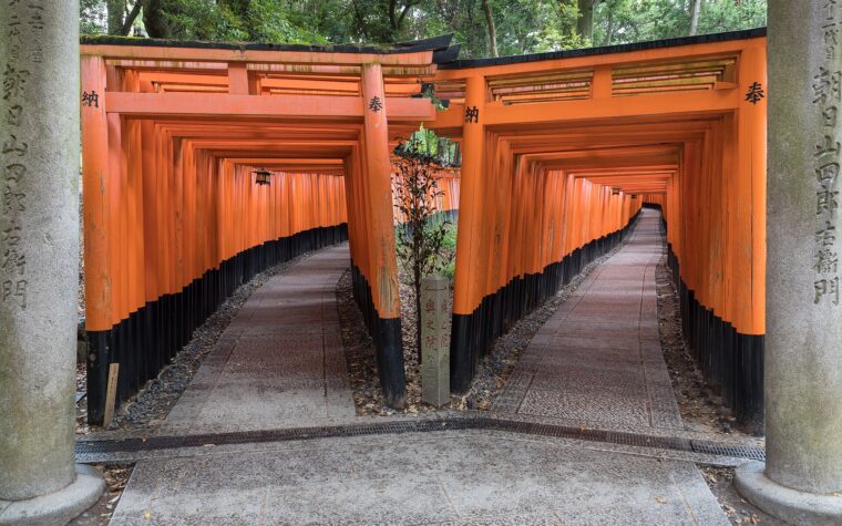 ทางเดินแยกใต้แนวเสาโทริอิสีชาดที่ศาลเจ้าฟูชิมิอินาริในเกียวโต