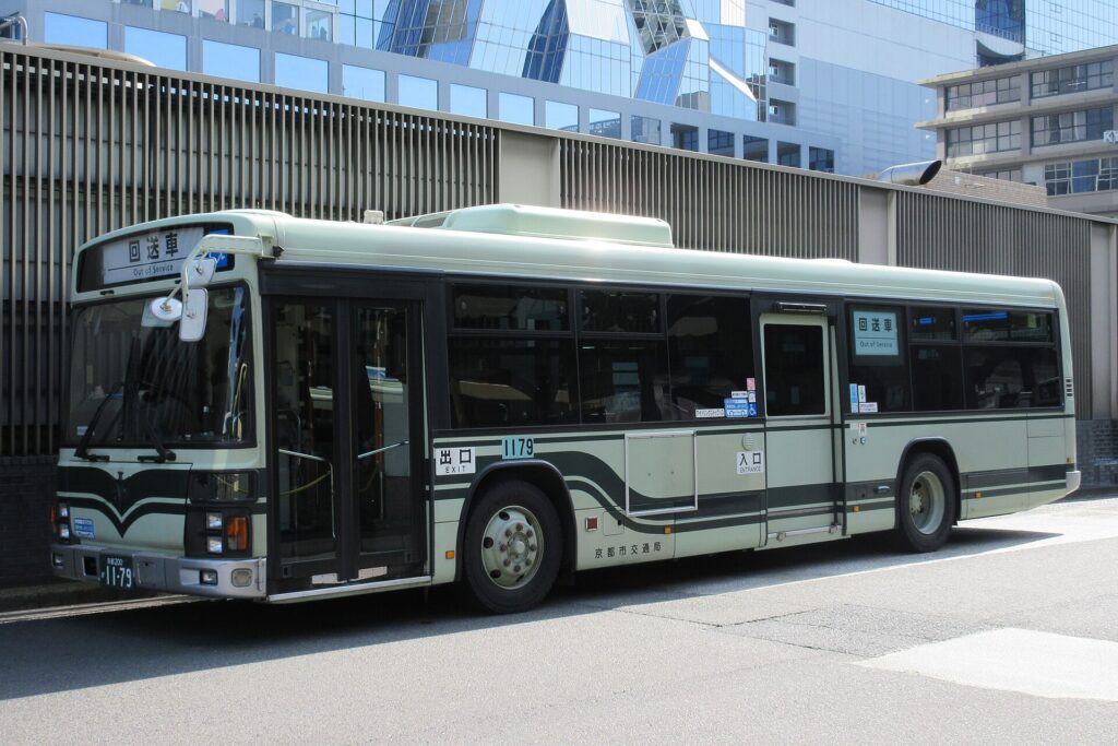 รถ Kyoto City Bus สีเขียวอ่อนจอดอยู่ข้างสถานีเกียวโต