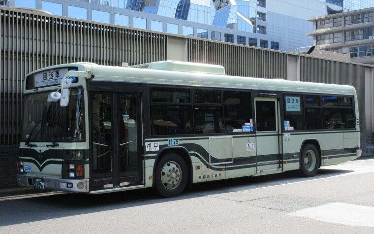 รถ Kyoto City Bus สีเขียวอ่อนจอดอยู่ข้างสถานีเกียวโต