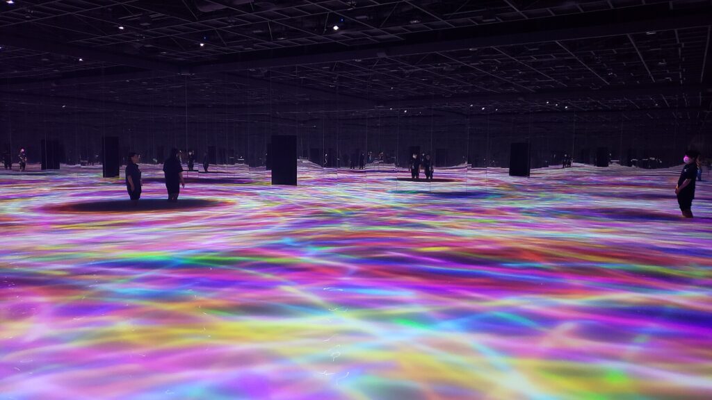 ห้องศิลปะดิจิทัล teamLab Planets มีแสงหลากสีสะท้อนบนพื้นน้ำและผนังกระจก