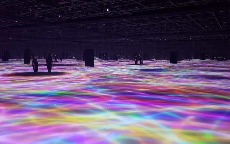 ห้องศิลปะดิจิทัล teamLab Planets มีแสงหลากสีสะท้อนบนพื้นน้ำและผนังกระจก