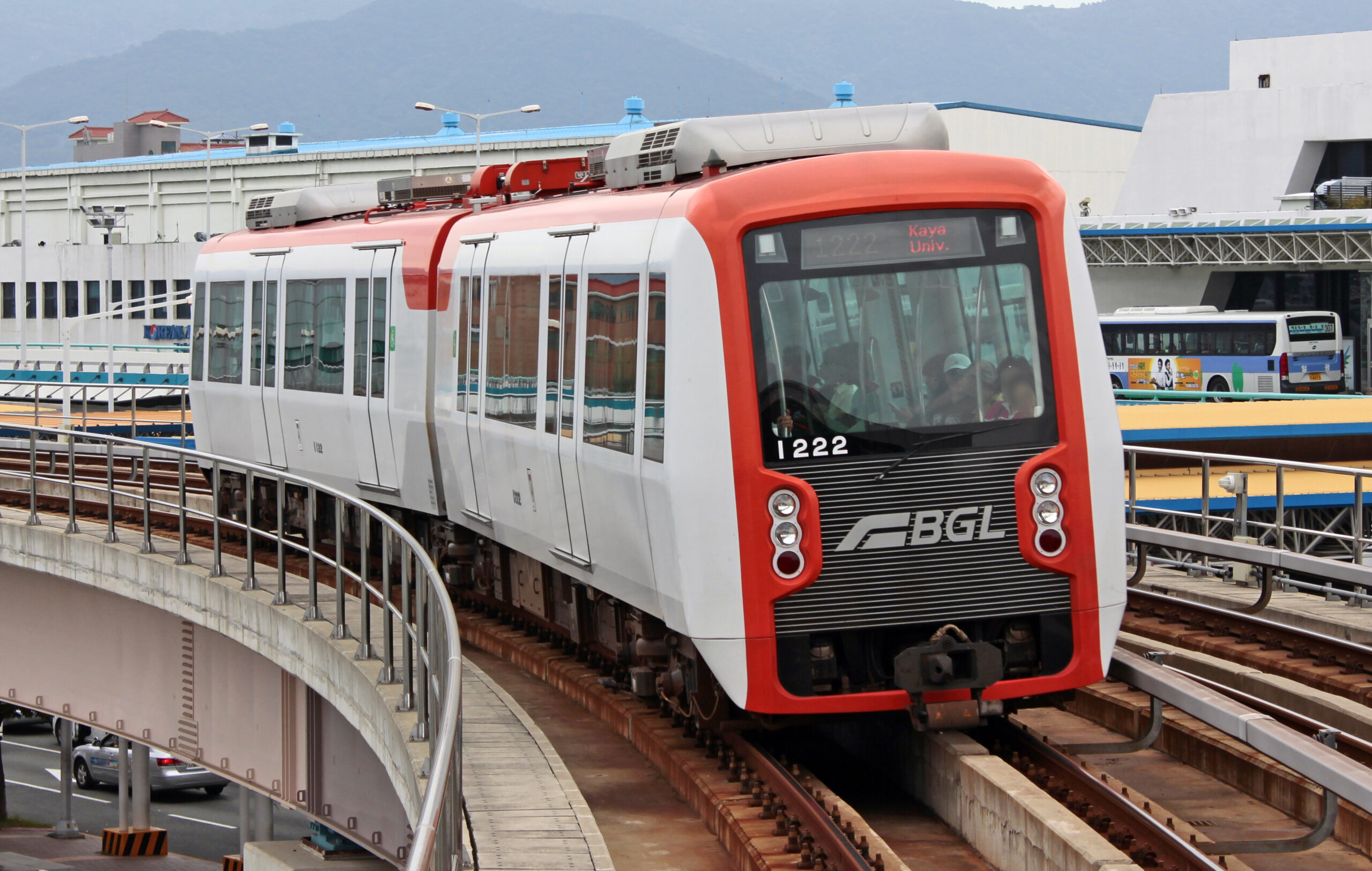 รถไฟ Busan-Gimhae Light Rail Transit สีขาวแดงใกล้สถานีสนามบินกิมแฮ