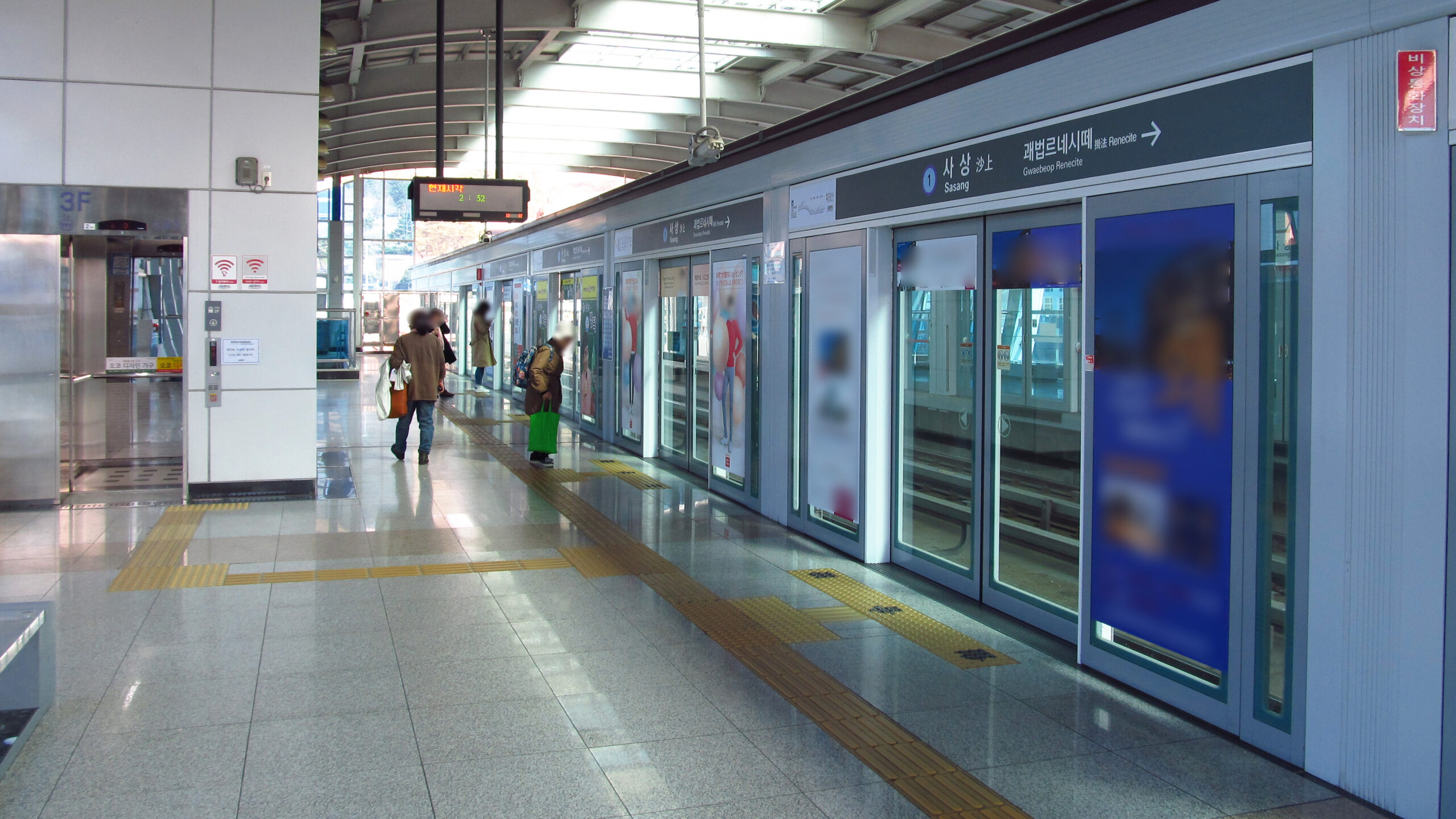 ชานชาลารถไฟ Busan-Gimhae ที่สถานีสาสังพร้อมป้ายบอกทิศทางและประตูกั้นชานชาลา