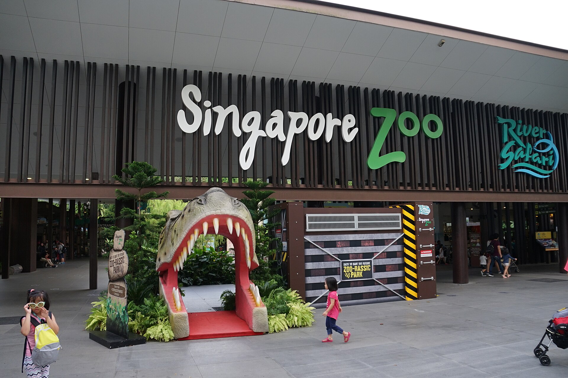 ทางเข้า Singapore Zoo พร้อมป้ายชื่อสถานที่และพื้นที่ต้อนรับผู้เข้าชม