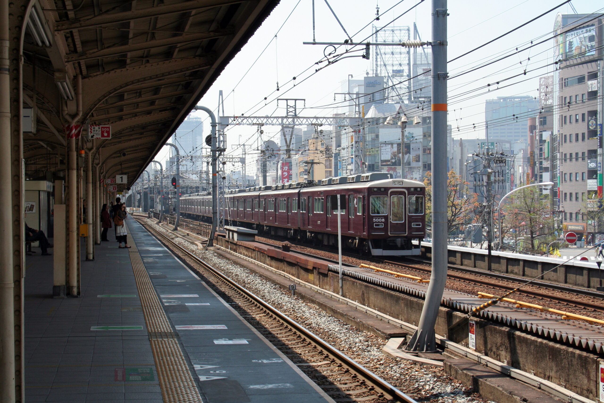รถไฟ Hankyu สีแดงเลือดหมูเข้าสู่ชานชาลาสถานี Kobe-Sannomiya