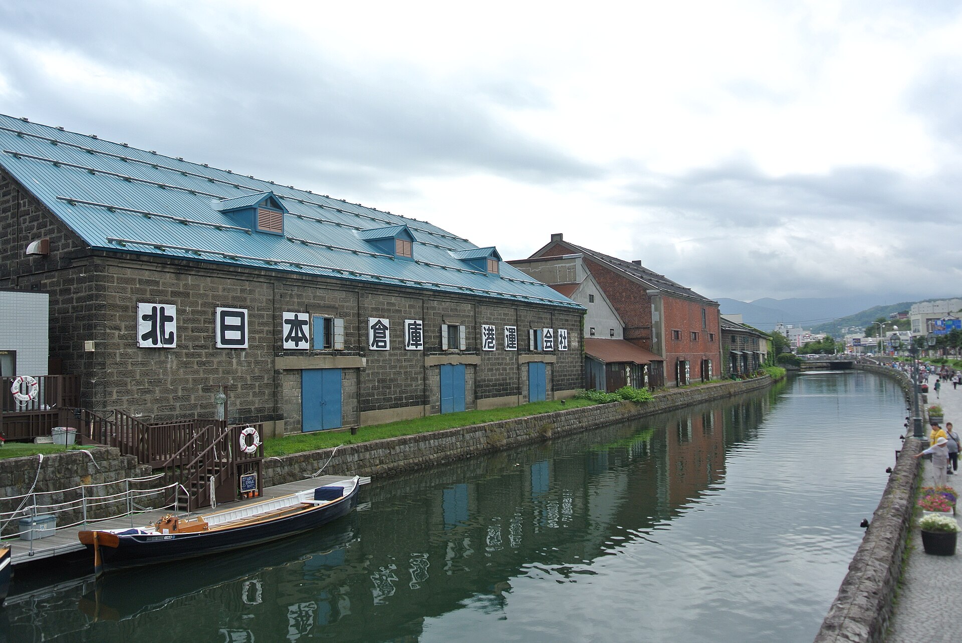คลองโอตารุ เรือท่องเที่ยว และอาคารคลังสินค้าหลังคาสีน้ำเงินริมคลอง