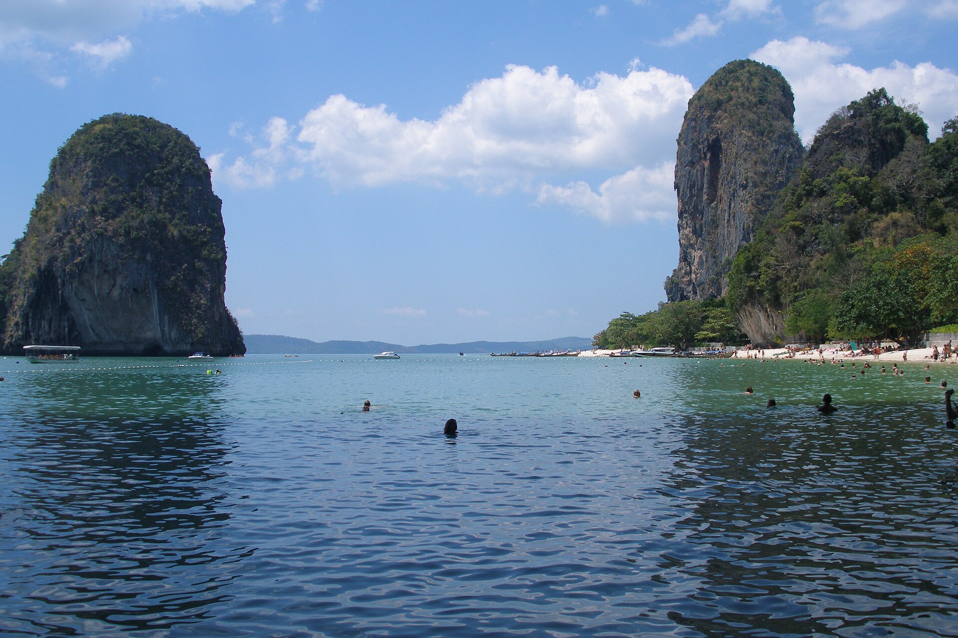 หาดไร่เลย์ จังหวัดกระบี่ หินปูนสูง น้ำทะเลสีเขียว และเรือหางยาว